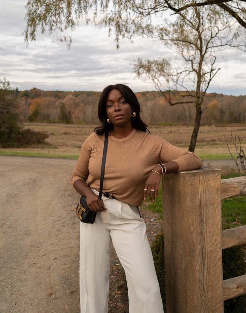 Woman wearing white trousers an a tan, knit tip.