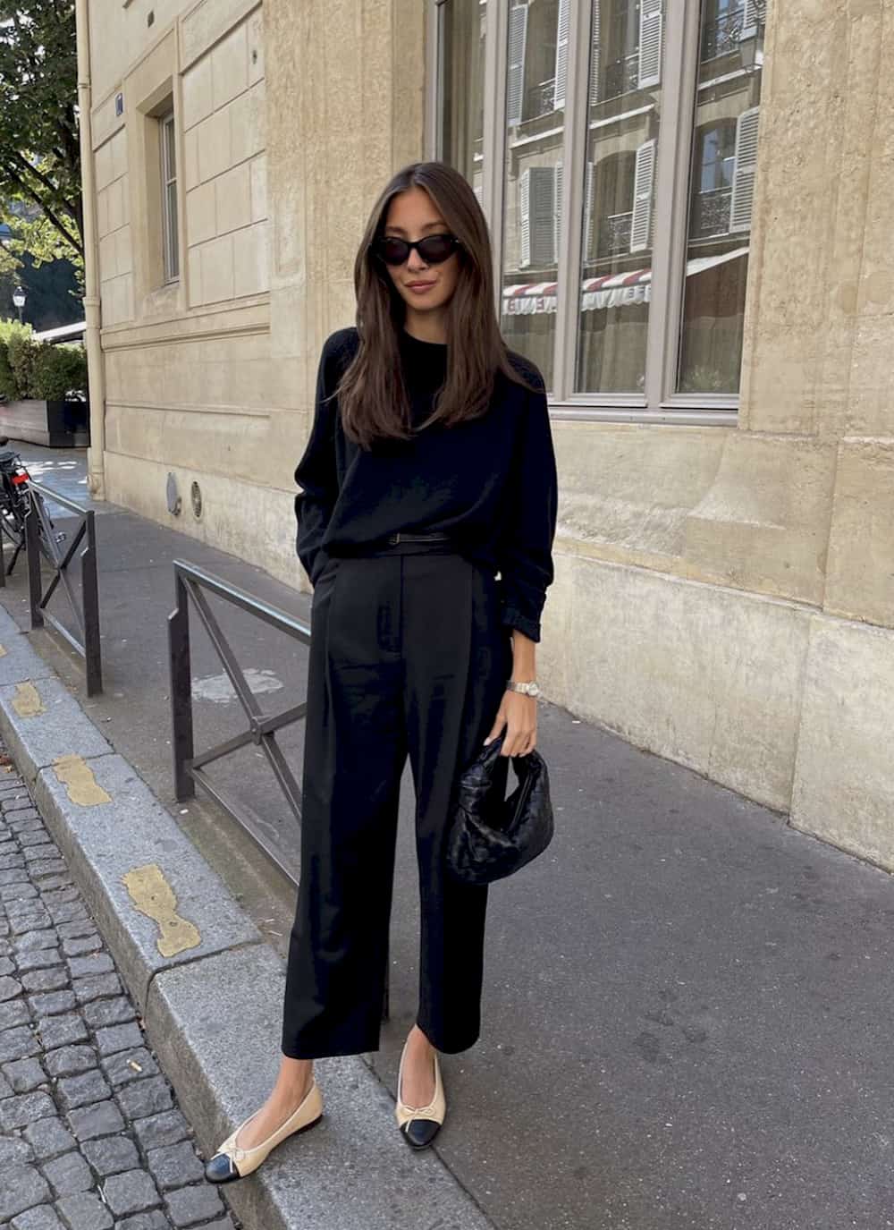 Woman wearing black trousers and a black sweater.
