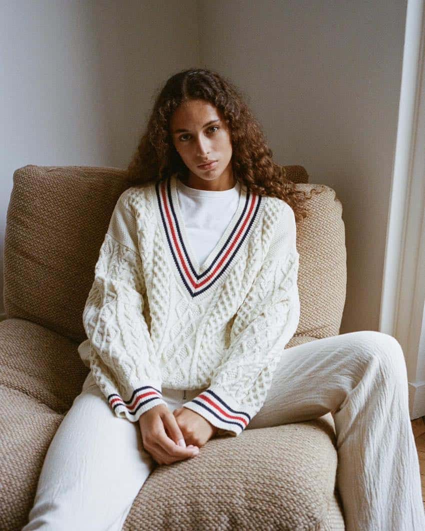 Woman wearing white pants with a white t-shirt and a white sweater.