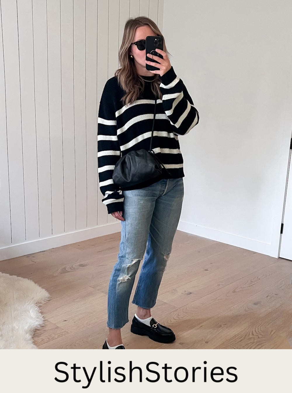 image of a woman wearing a striped black sweater with blue jeans and chunky black Gucci loafer dupes from H&M