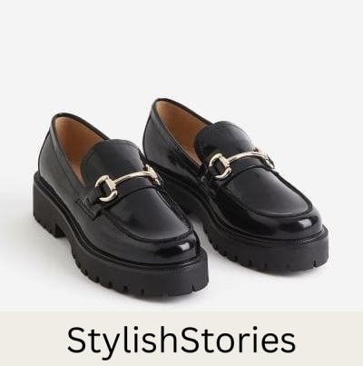 image of a pair of black chunky leather loafers with a gold horse-bit detail