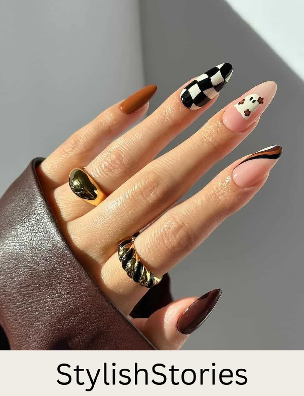 long almond nails featuring brown nail polish, ghost nail art, and checkerboard details
