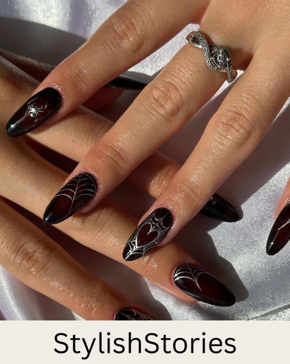 long red and black aura almond nails with silver Halloween nail art