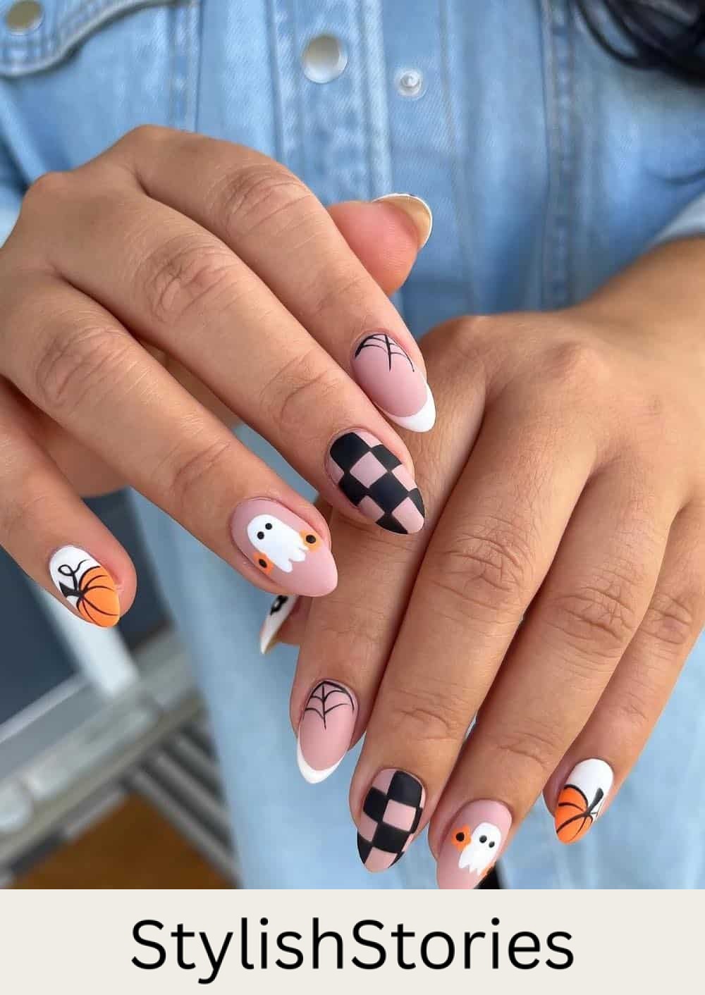 medium nude pink almond nails with pumpkin tips, ghost art, spider webs, and checkerboard details