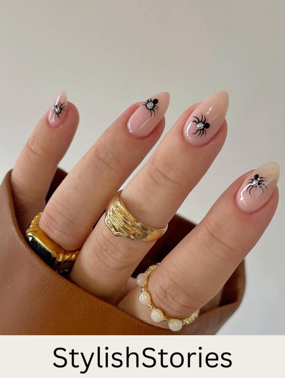 short nude almond nails with black and silver spiders