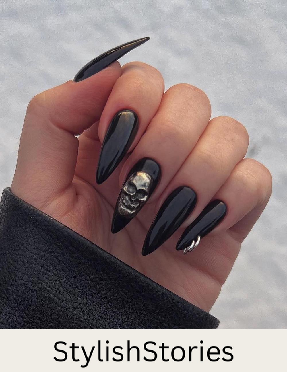 long black stiletto nails with a 3D skull and nail piercings