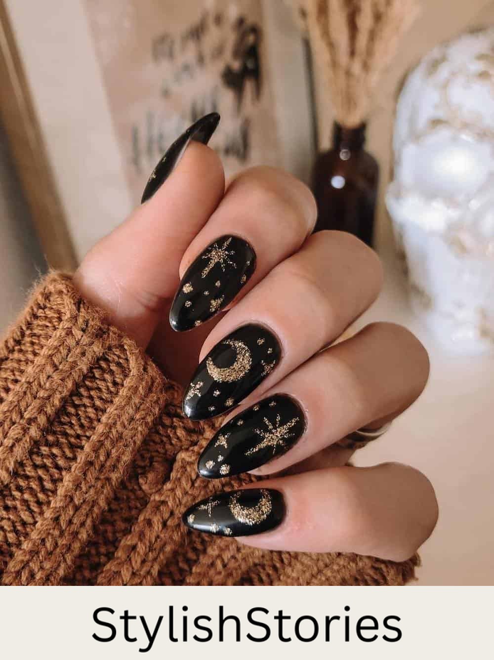 long black almond nails with gold glitter stars and moons