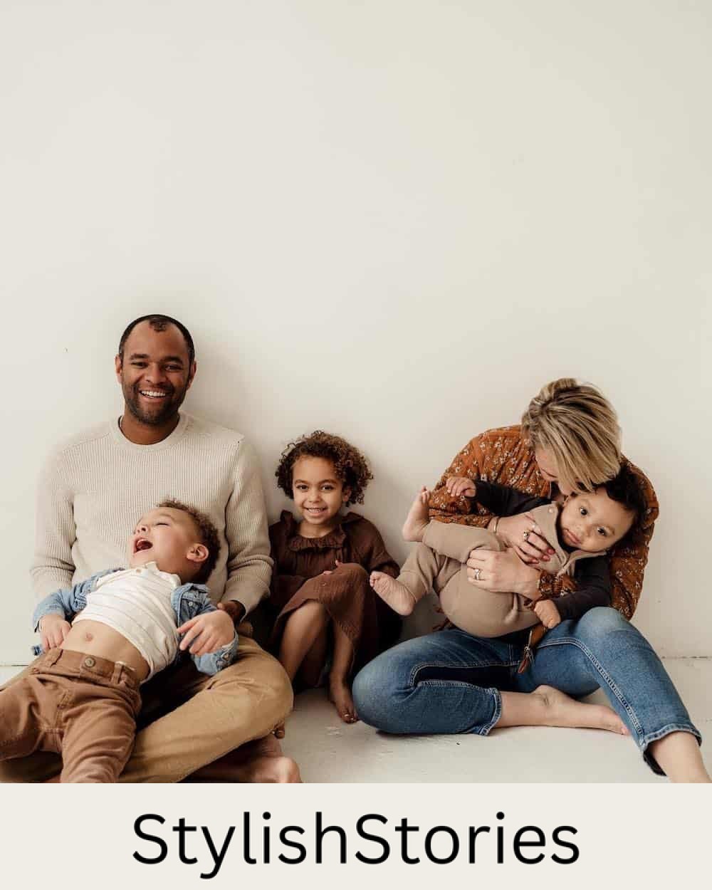 image of an indoor fall family photoshoot with everyone wearing shades of brown, jeans, and mom in a mustard floral shirt