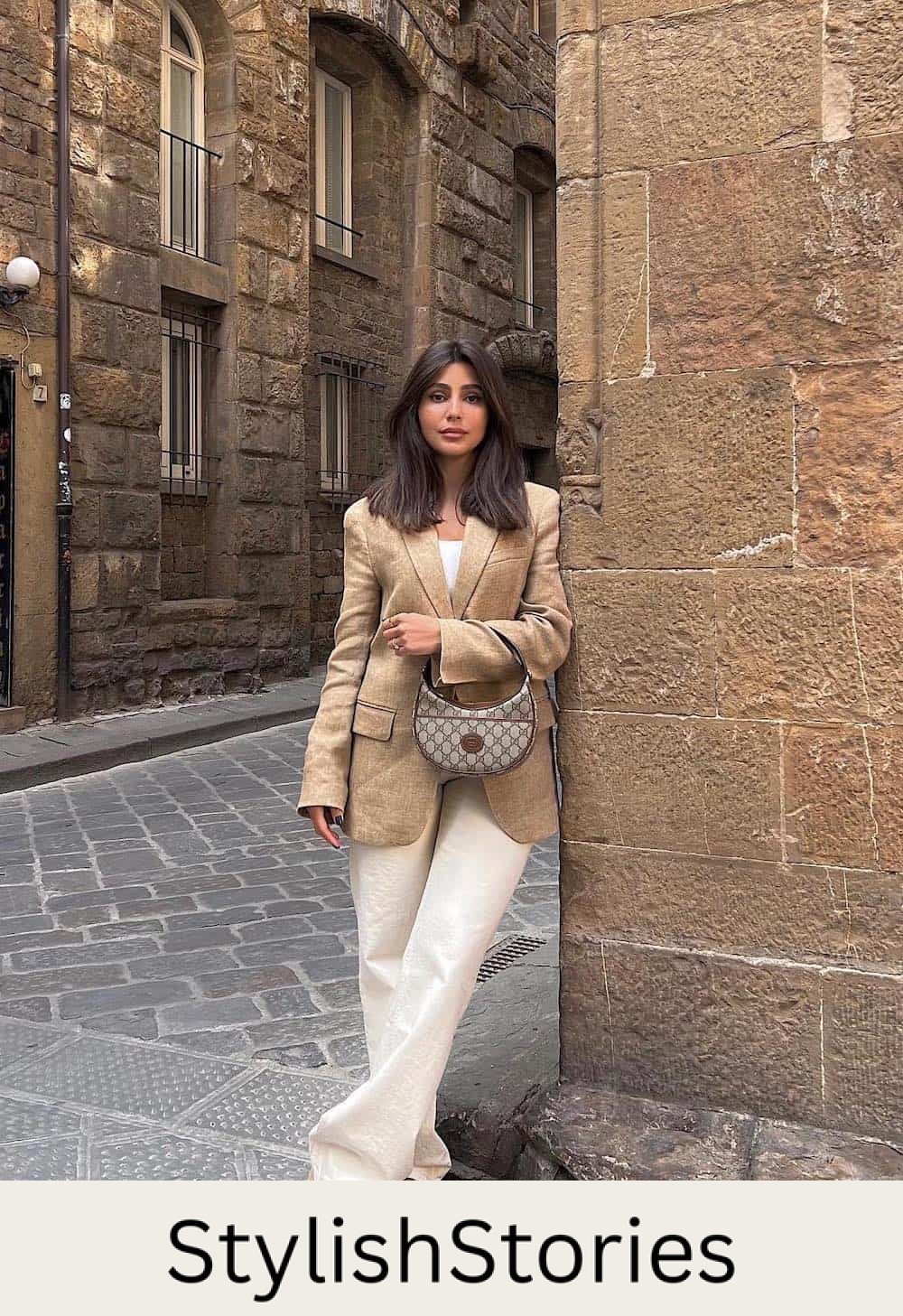 Woman wearing linen pants, Ugg Tasman boots, and a tan blazer.