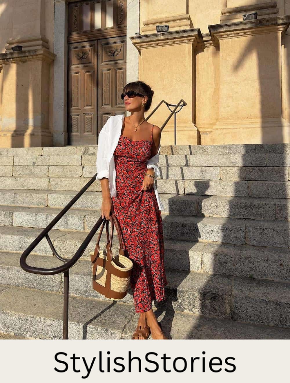 Woman wearing a red floral printed midi dress with brown sandals and a rattan bag.