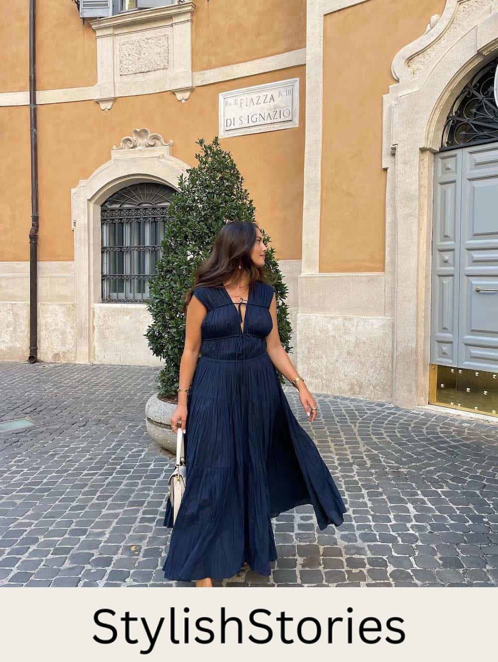 Woman wearing a navy blue maxi dress with brown sandals.