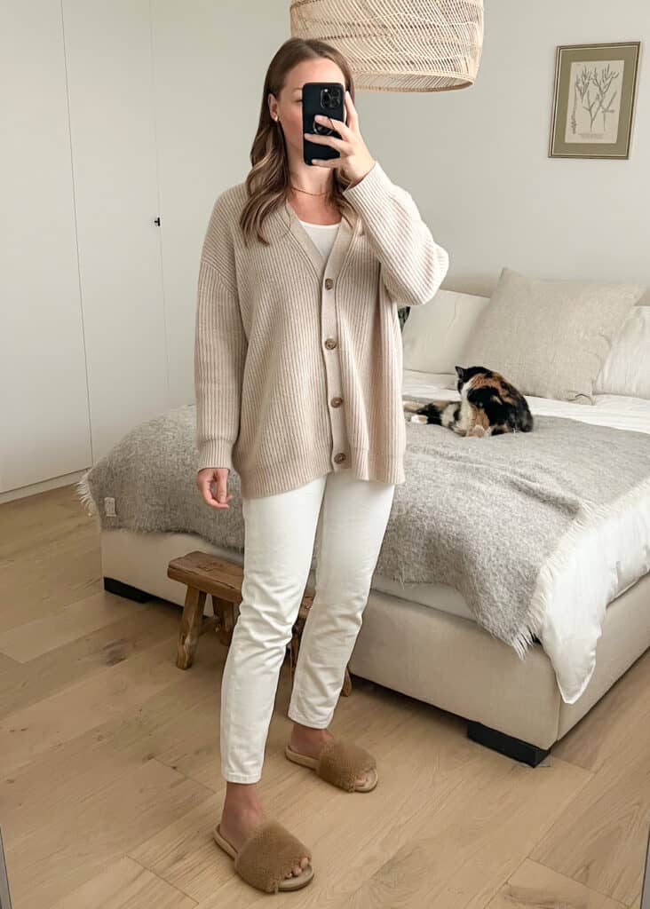 Christal wearing the Jenni Kayne cashmere cocoon cardigan in Oatmeal with white jeans and shearling slides