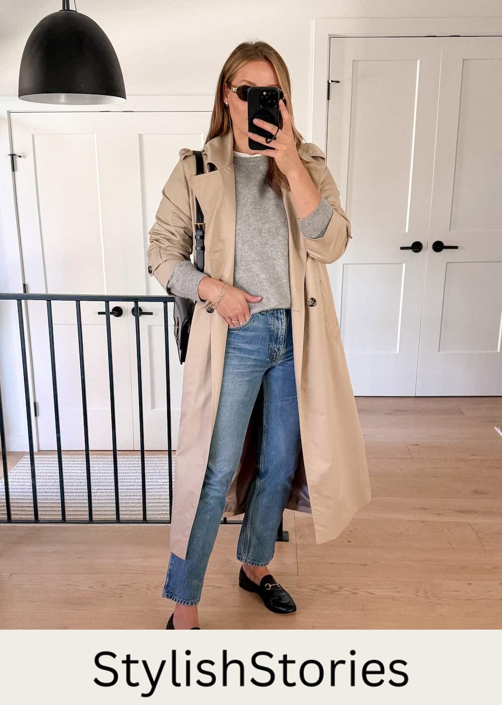 Christal wearing straight jeans with a trench coat over a sweater and loafers.