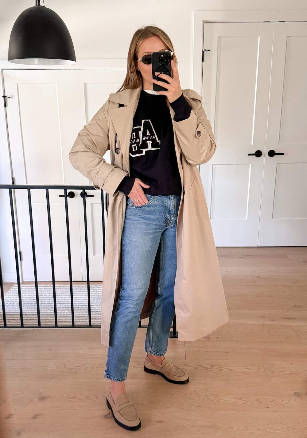 Christal wearing straight jeans with loafers and a trench coat.