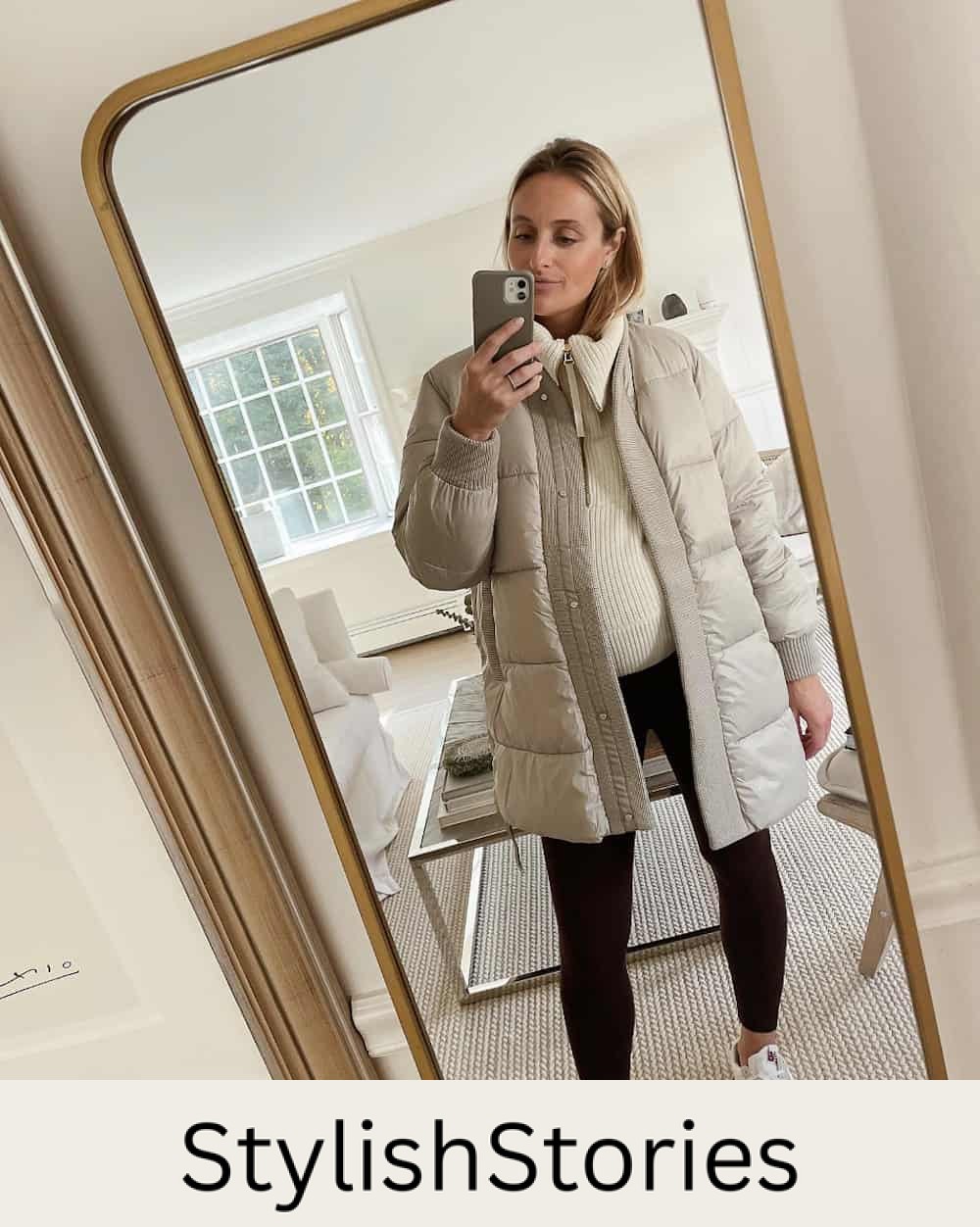 Pregnant woman wearing a down coat over a knit sweater with leggings
