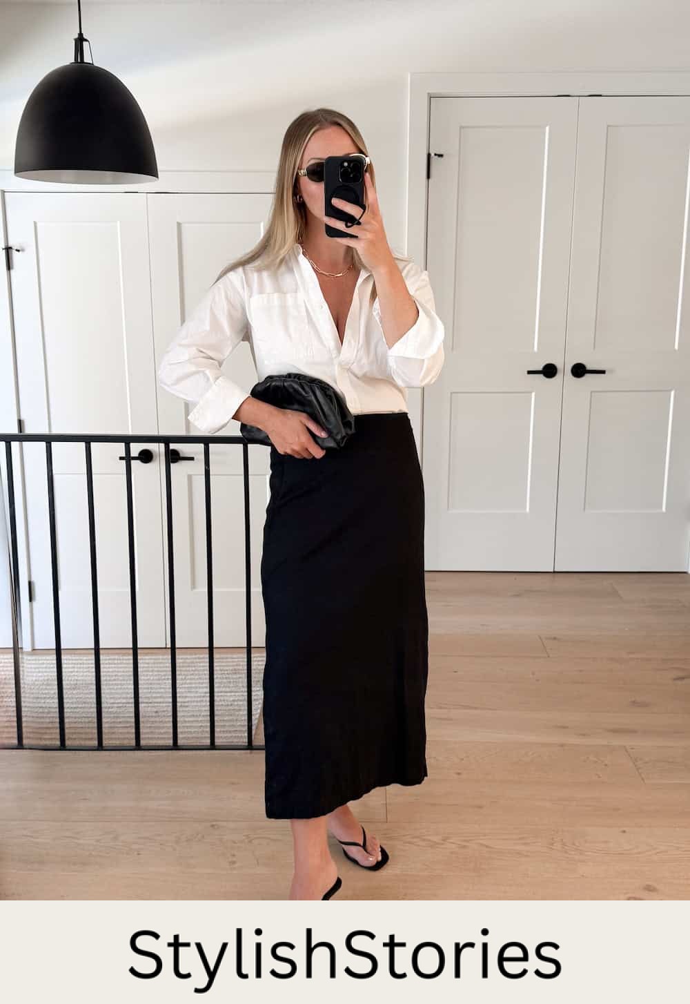 Christal wearing a black maxi skirt with a white top and heeled sandals.