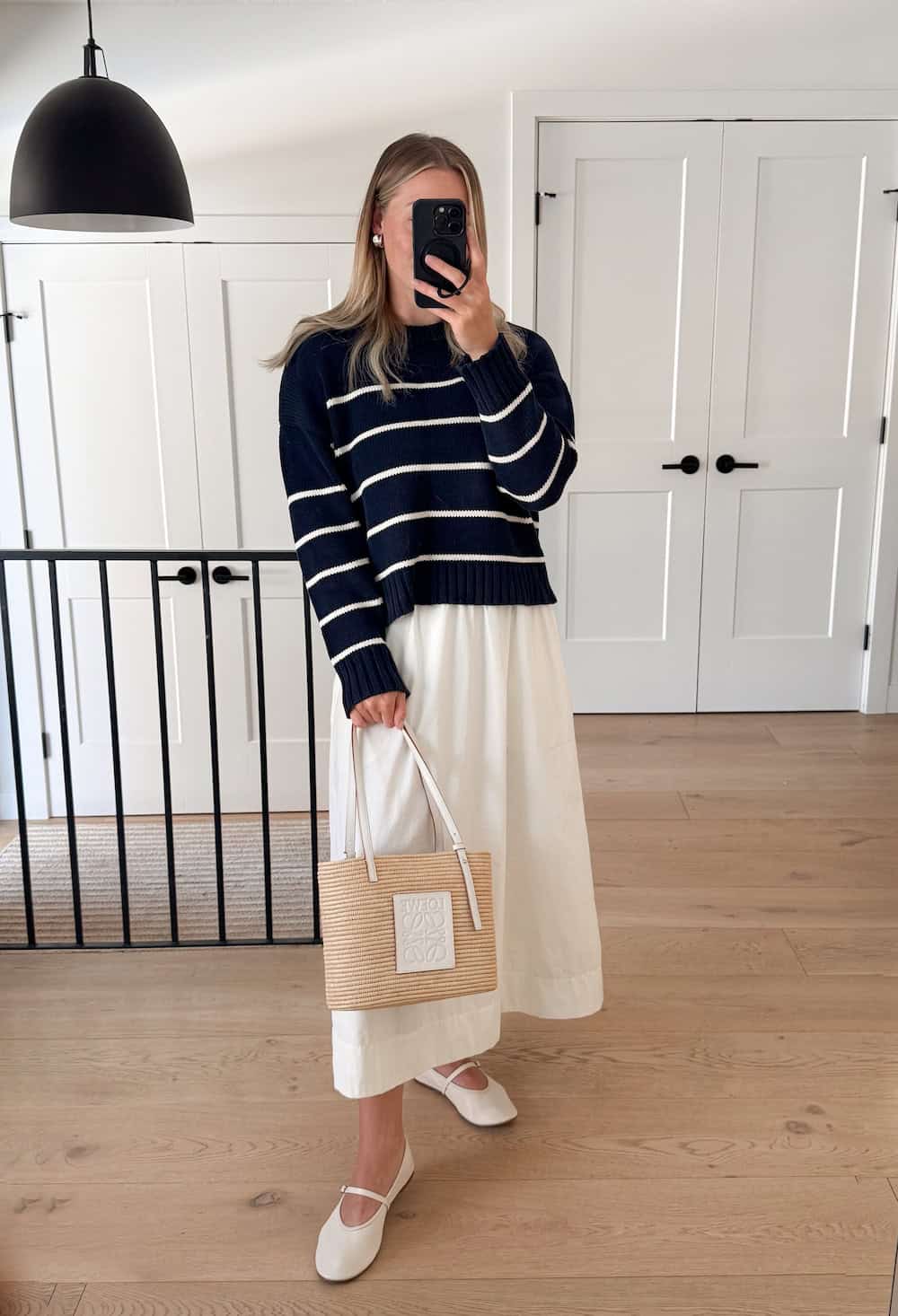 Christal wearing a white maxi skirt with a black and white striped sweater and white flats.