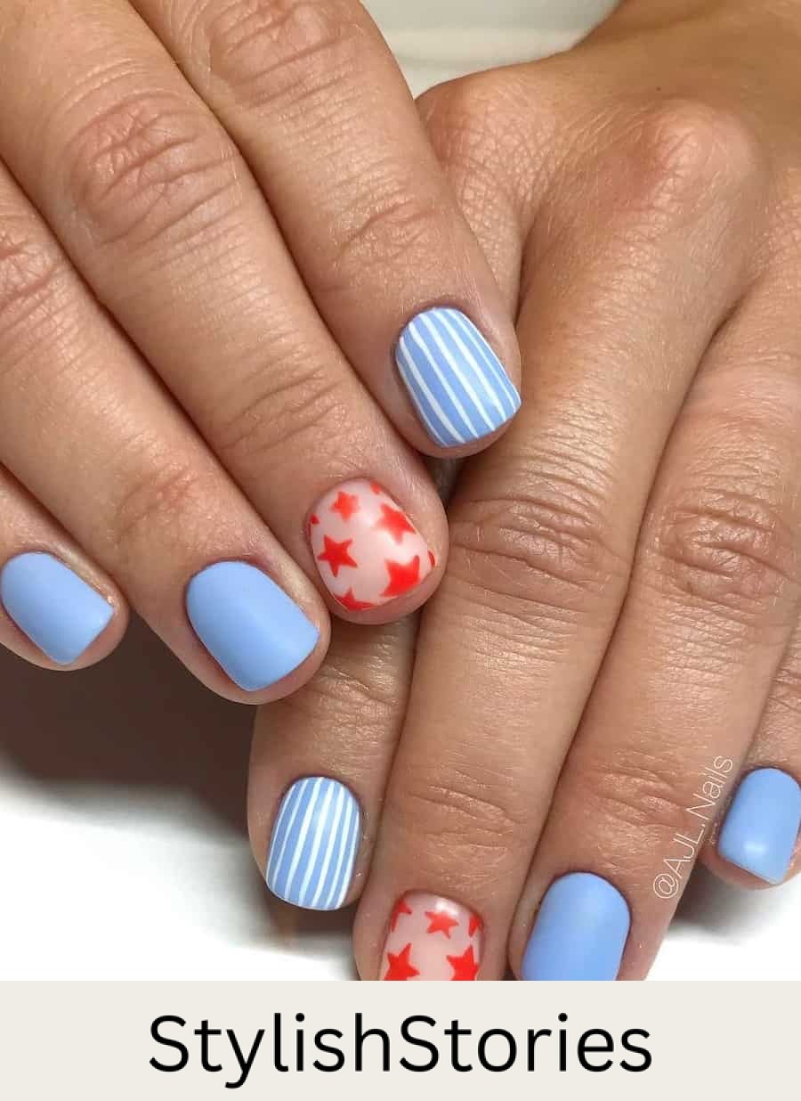 short square nails painted a pastel blue featuring a striped accent nail and another accent nail with nude polish and red stars
