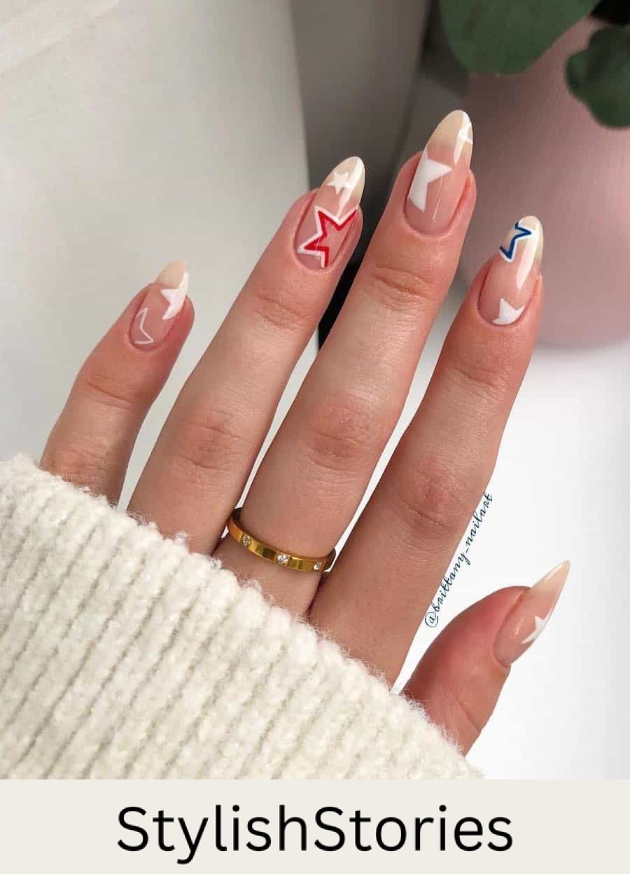long nude almond nails with white stars and red and blue accent stars