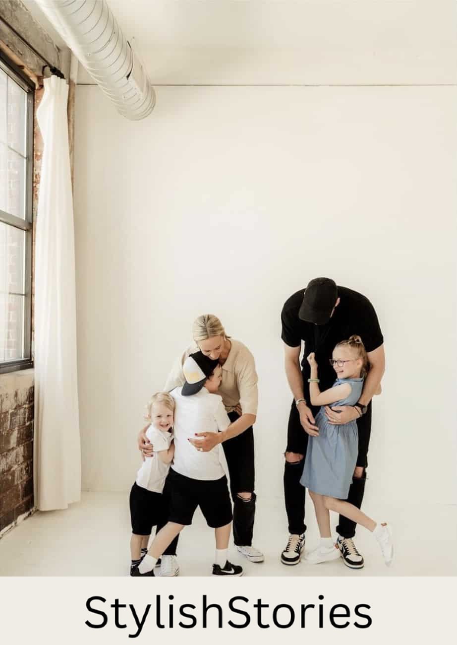 image of a family having a photoshoot wearing neutral colors including white black, beige, and denim