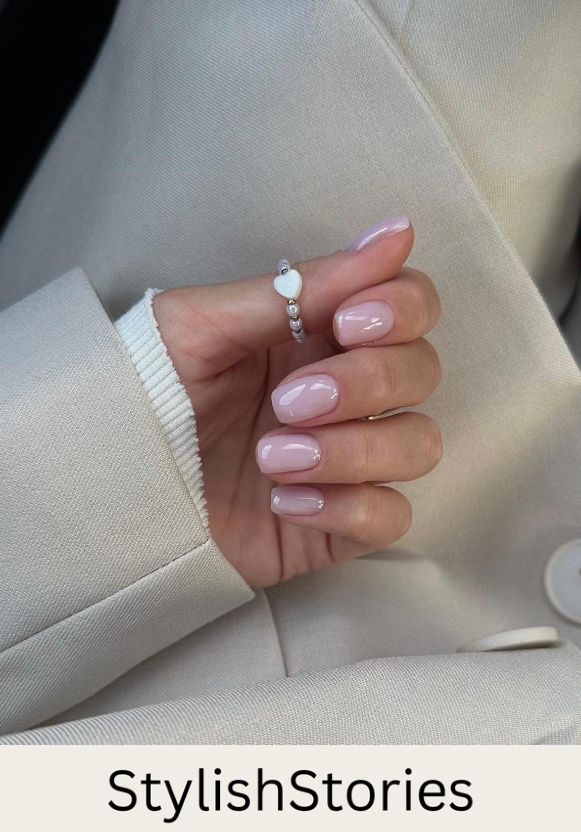 A hand with short soft nude pink nails