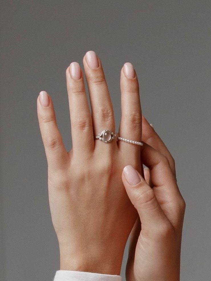 A hand with short nude nails