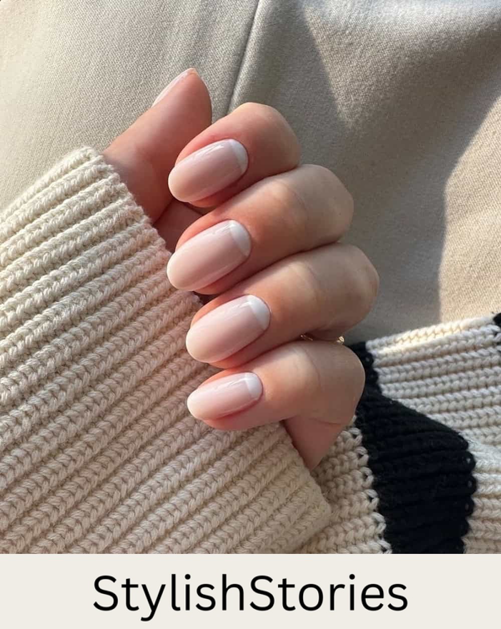 short round nails with nude polish and white reverse french tips