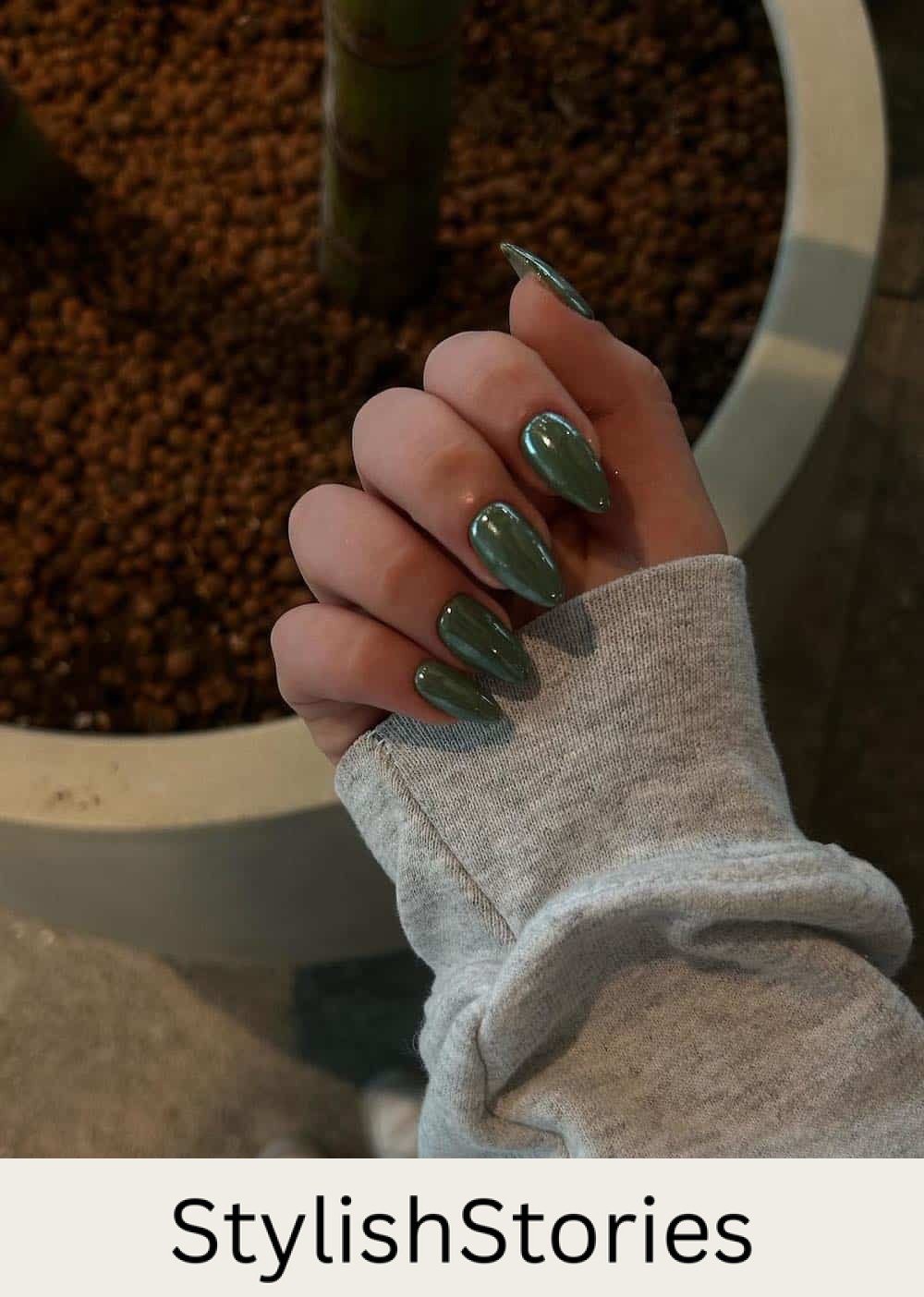image of a hand with olive green chrome nails