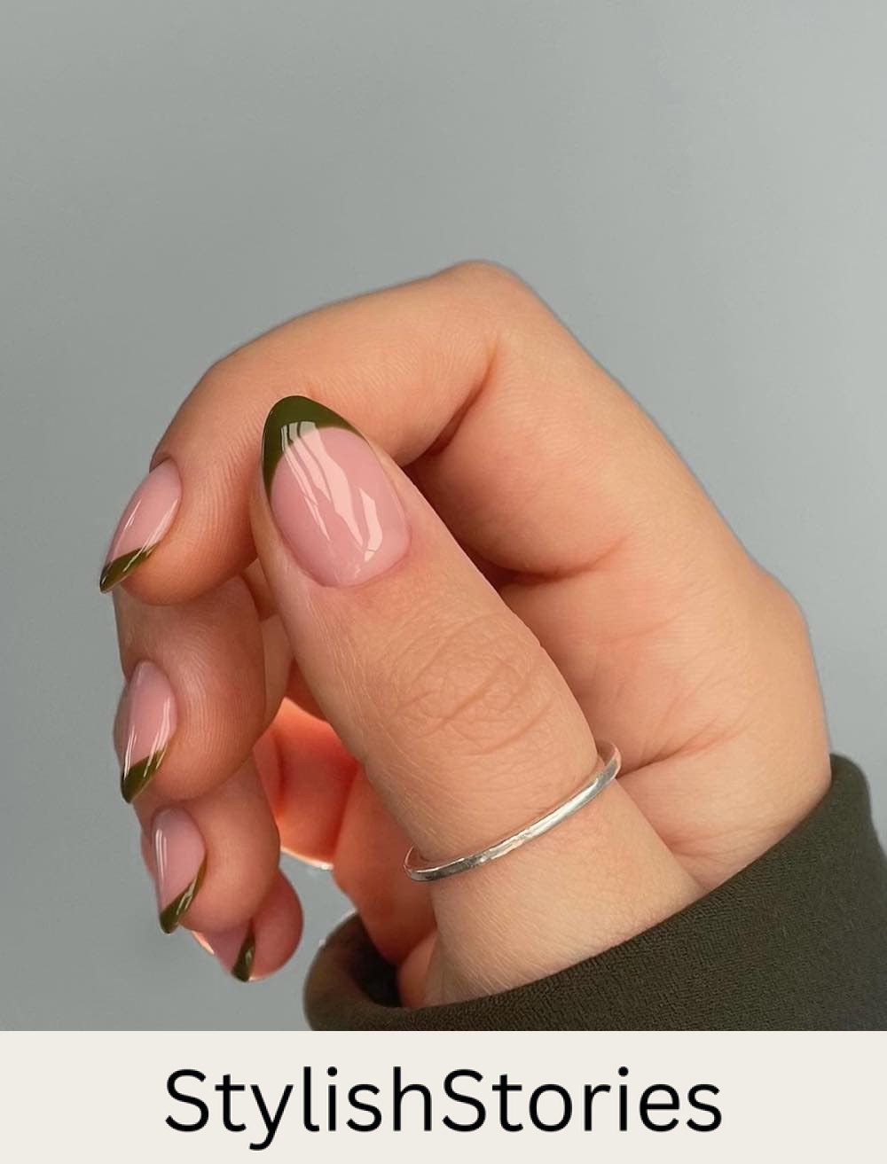 image of a hand with nude nails and olive green french tips