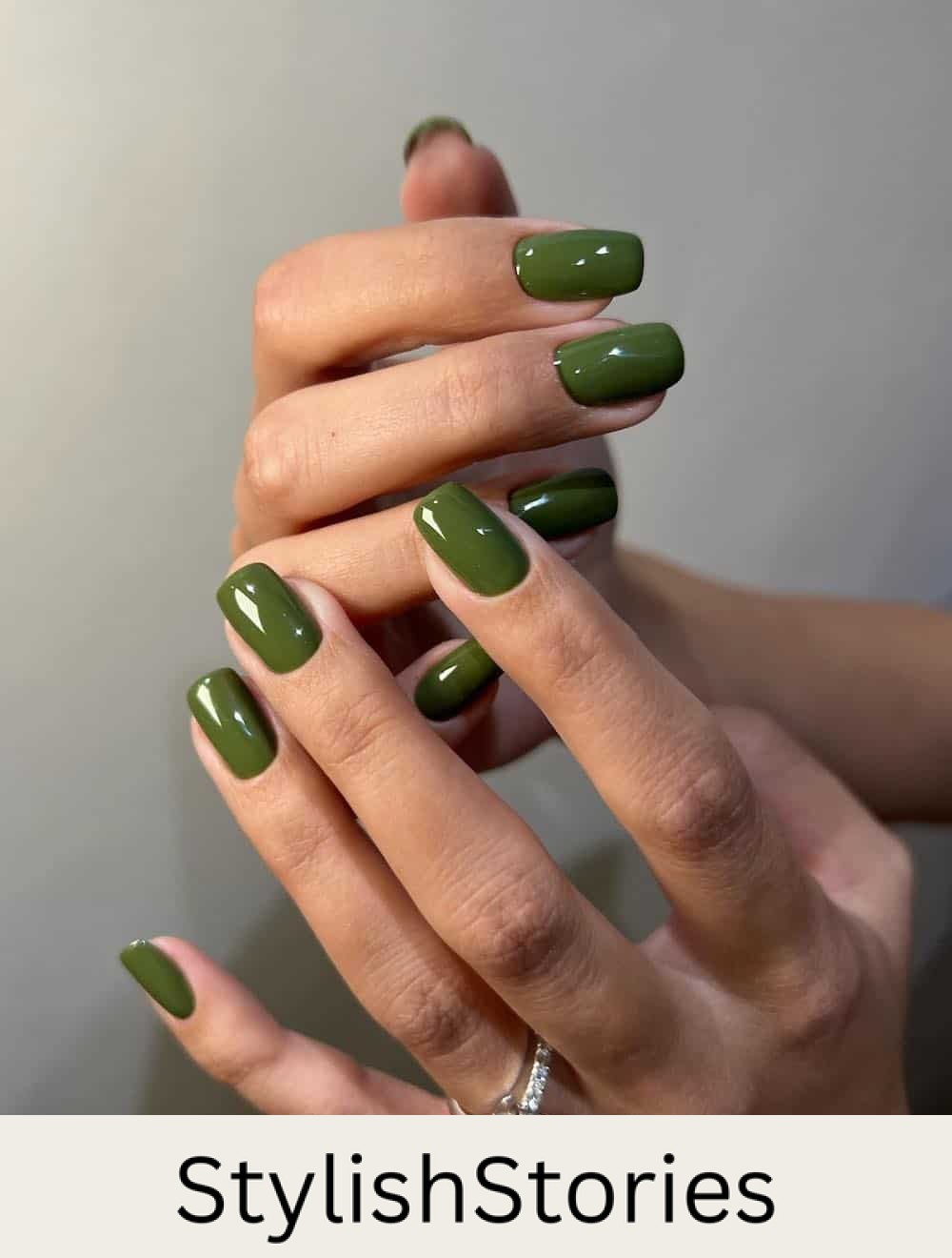 image of a hand with square-shaped glossy olive green nails