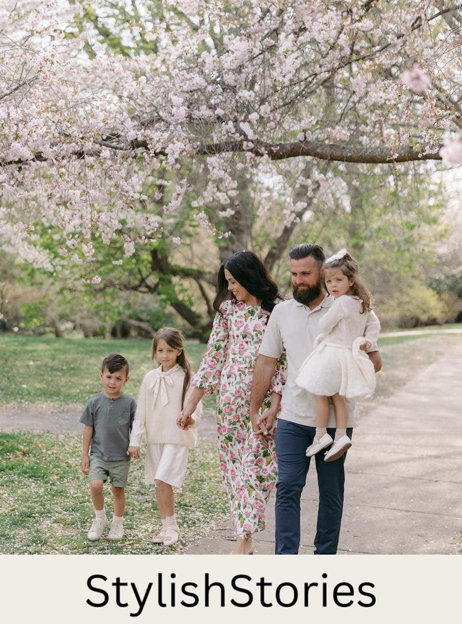 A spring family photo for a family of 5 featuring a floral dress on the mom, white outfits for the daughters, and short sleeved tees for the father and son