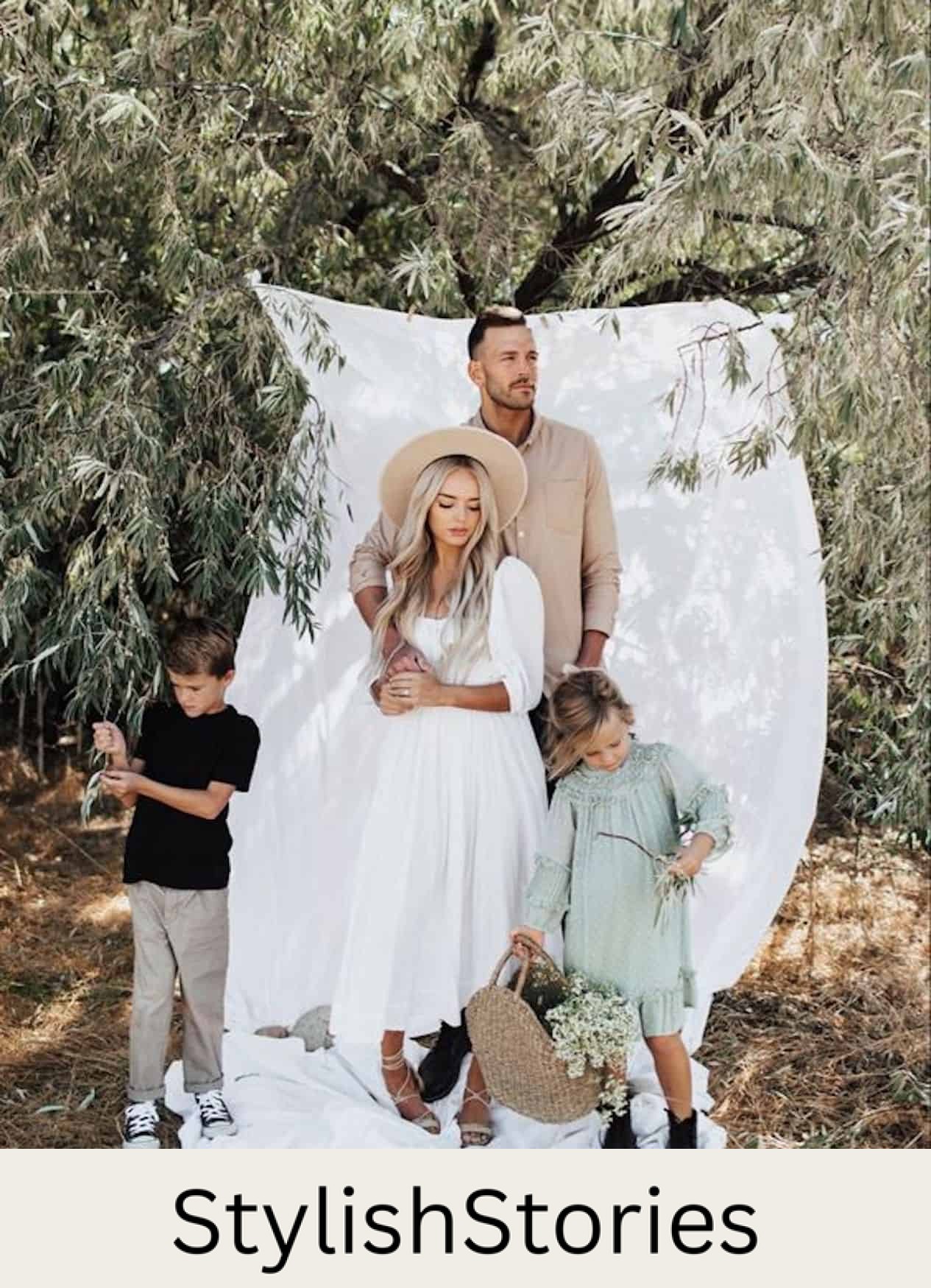 image of a family in a field with a tree in the background and a large white hanging sheet, wearing dressy clothing