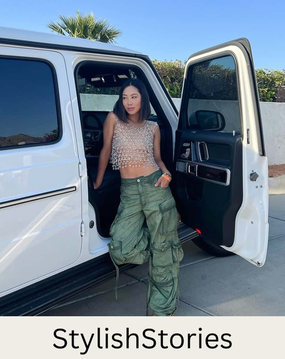 A woman wearing green cargo pants with a cropped crystal embellished tank top and colorful chunky sneakers