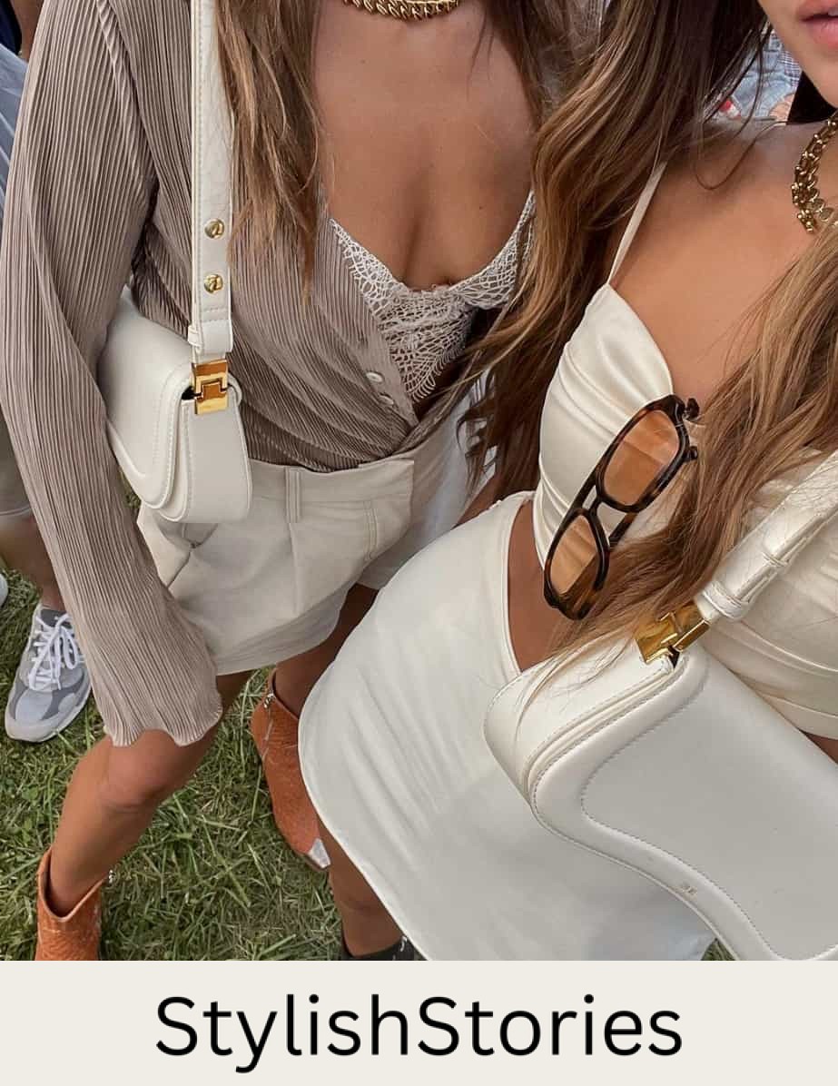 An overhead shot of two women wearing concert outfits, one wearing a white mini skirt and silky white crop top with black boots and the other wearing white shorts with a lacy corset top, a beige cardigan, and orange and silver cowboy boots