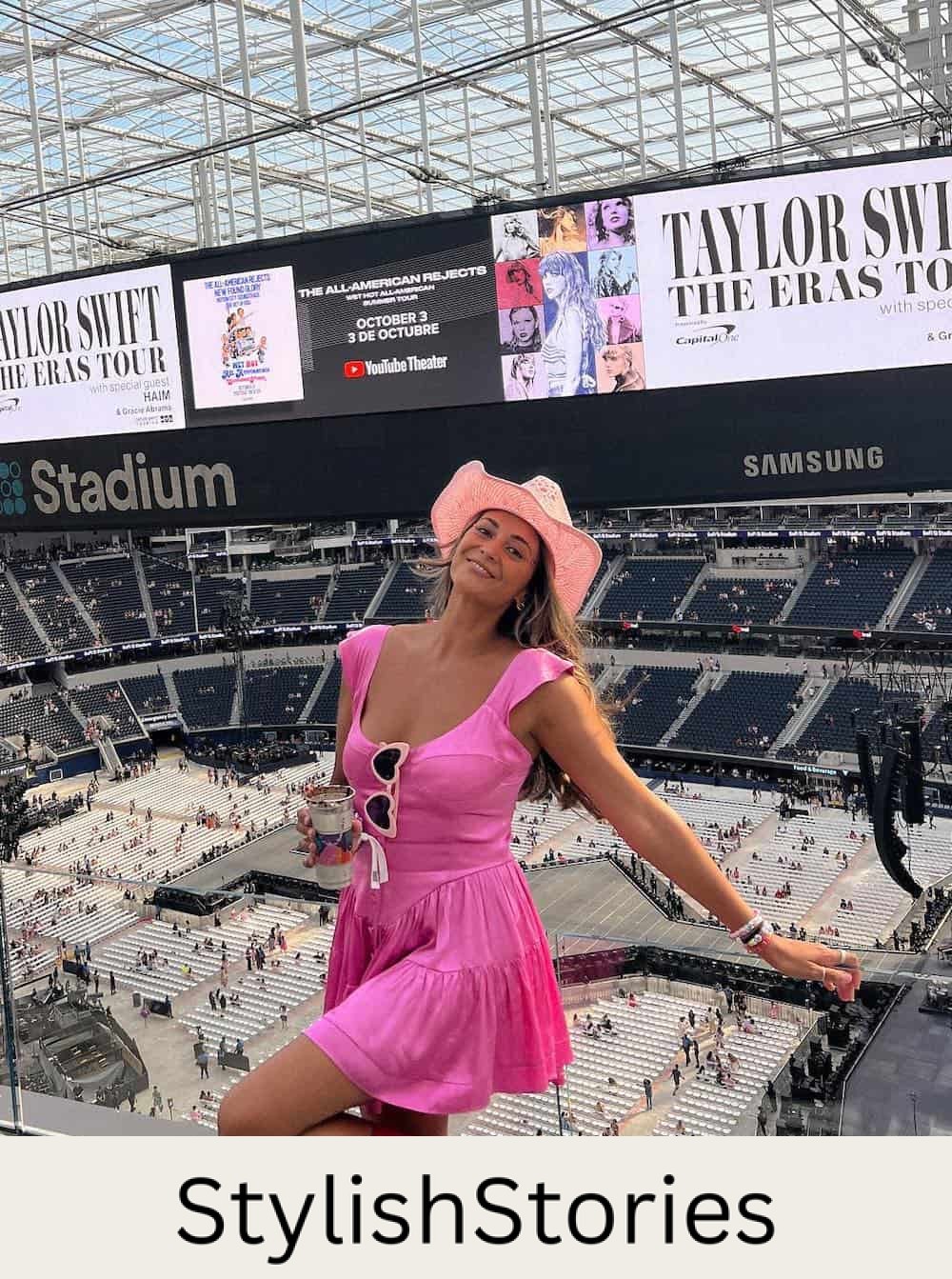 a woman wearing a summer concert outfit featuring a pink mini dress metallic pink cowboy boots, and a pink cowgirl hat