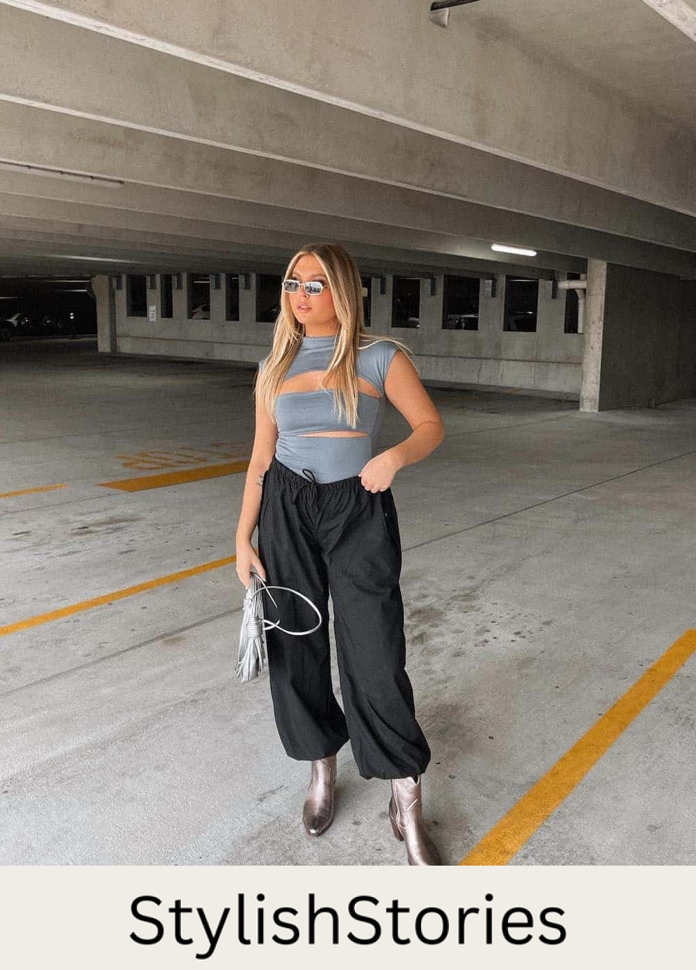 a woman wearing a grey top with cut-outs, black drawstring pants, and short metallic cowboy boots