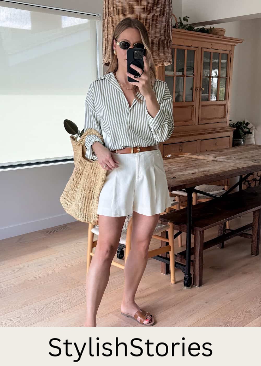 Christal wearing tailored shorts, a striped button down and brown sandals.