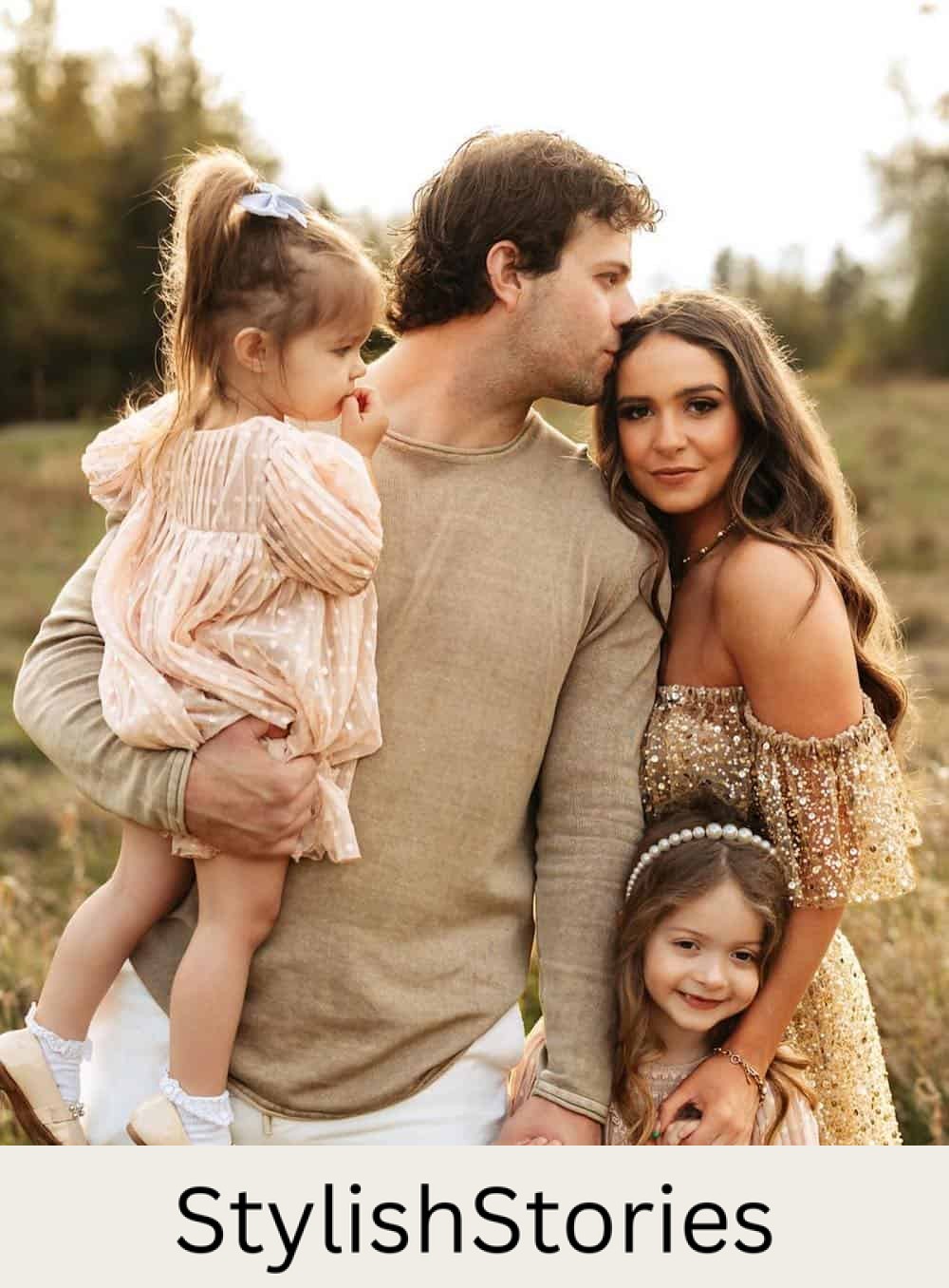 a summer family photo shoot where to mom is wearing an off-the-shoulder dress with gold accents while the dad wears neutral pieces and the daughters wear neutral polka dot dresses