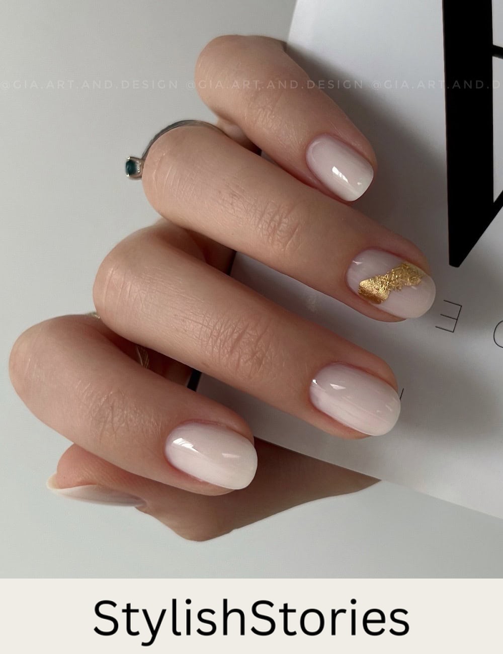 short round milky white nails with a gold foil accent nail