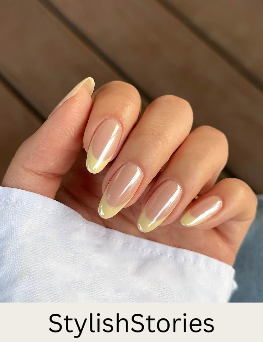 medium nude almond nails with butter yellow tips and a chrome finish