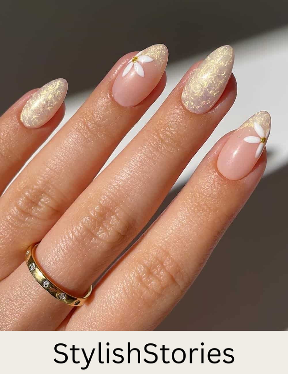 medium almond nails with a pearly yellow finish and french tip accent nails with floral art