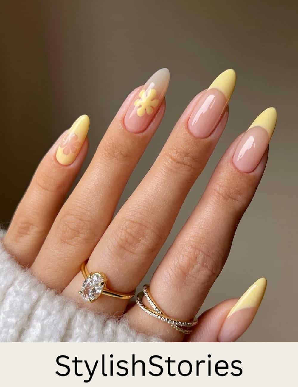 long nude almond nails with butter yellow french tips and floral accent nails