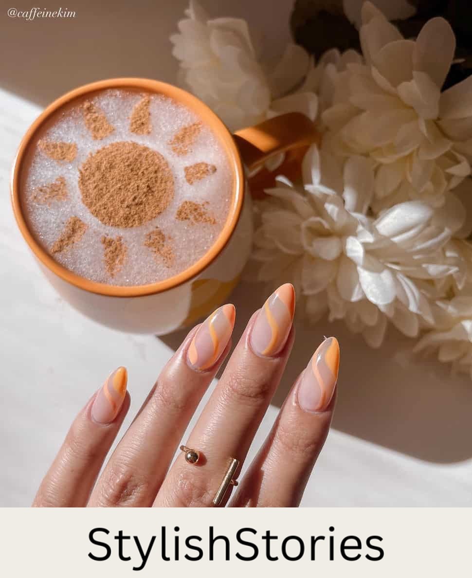 A hand with medium almond nails painted with a nude polish and accented with orange waves