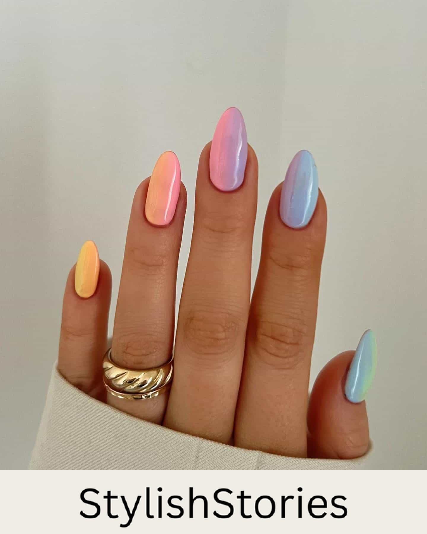 A hand with medium almond nails painted as a rainbow ombre