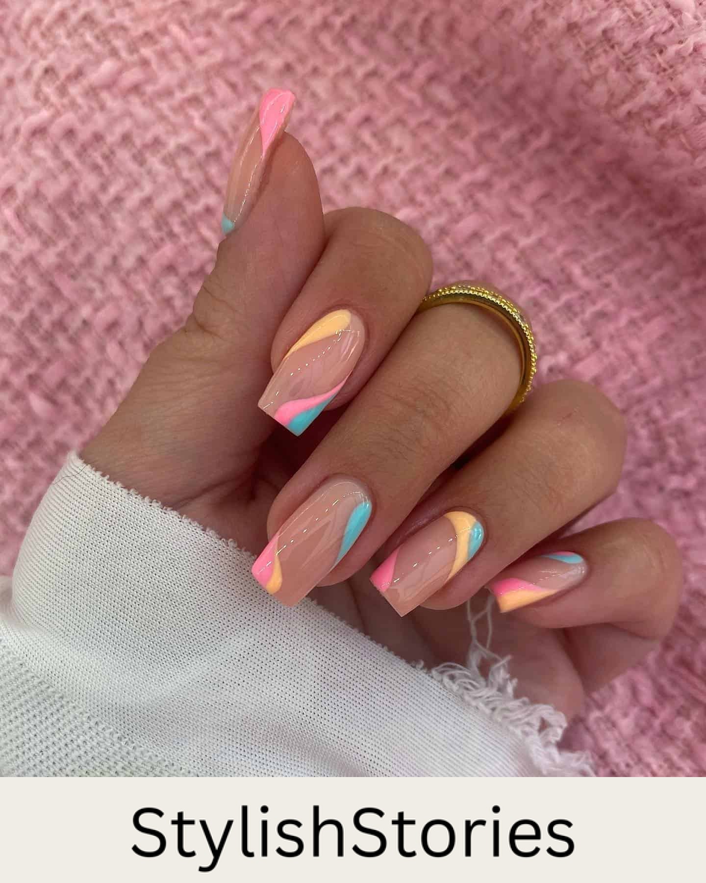 A hand with medium square nails painted a glossy nude color with orange, pink, and light blue wave accents