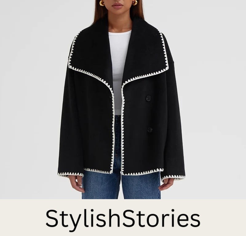 image of a woman wearing a black coat with a white contrast stitch detail on the trim - a look-alike of the Toteme scarf Jacket