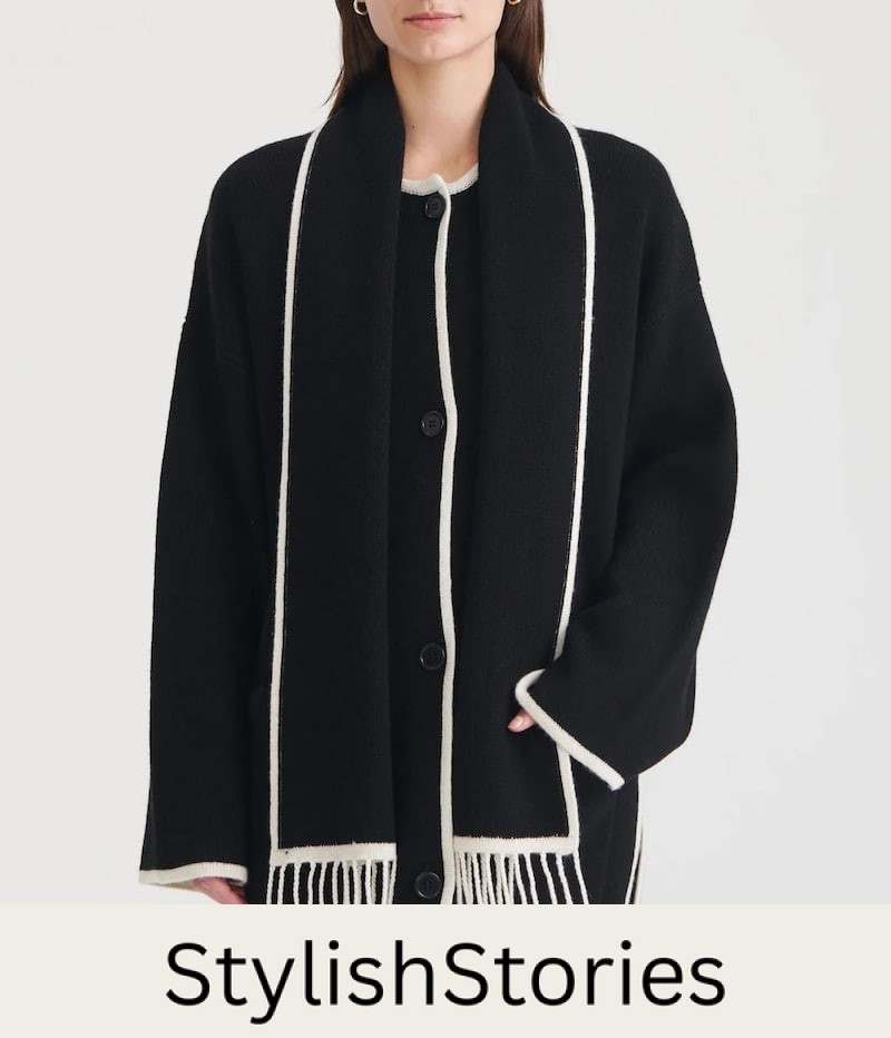 image of a woman wearing a black constrast stitch scarf jacket with white fringe that's a dupe of the Toteme scarf jacket