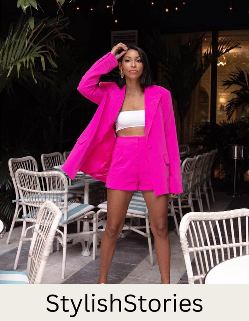 image of a black woman in a neon pink blazer and shorts set with a white tub top and shimmery heels