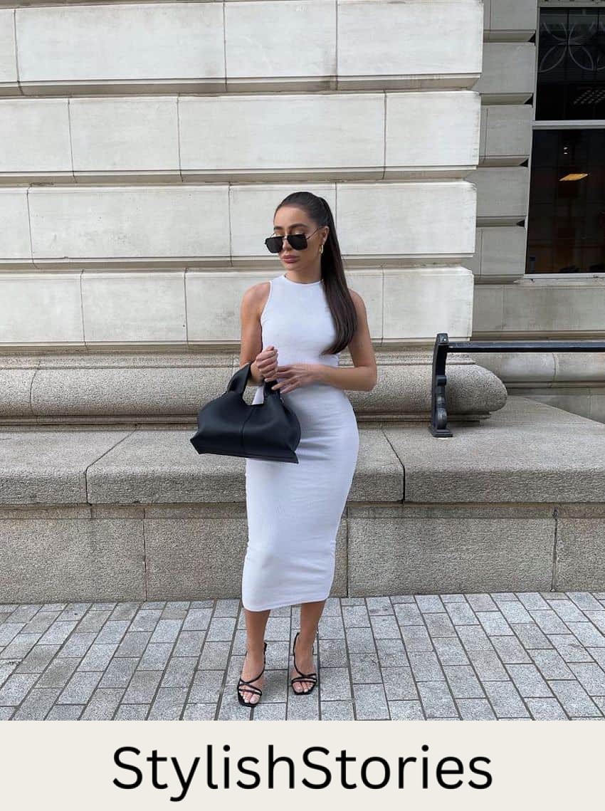 image of a woman in a long white body con dress, black sandals, with a black purse