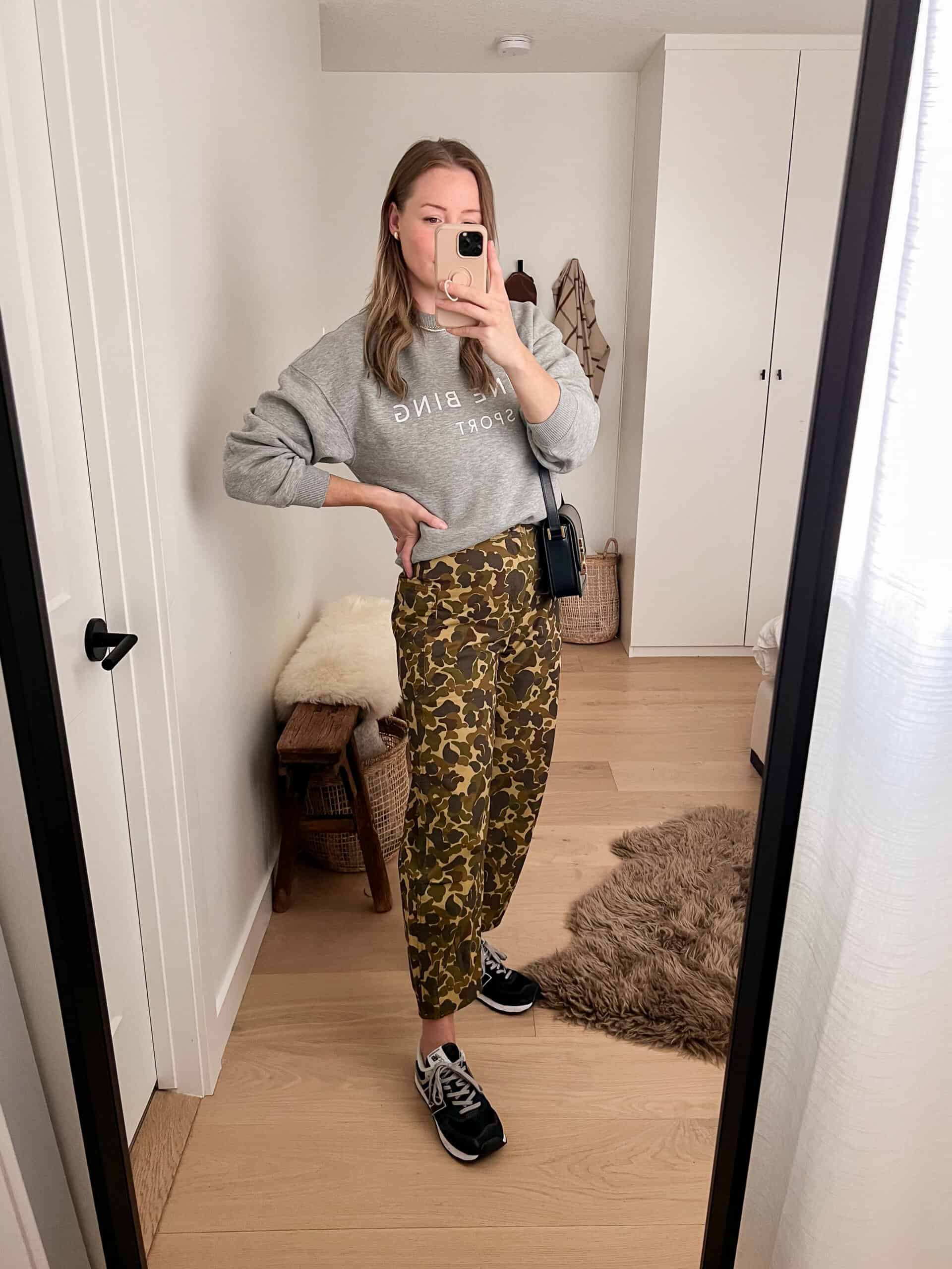 A woman wearing cargo pants with a grey sweatshirt and black trainers